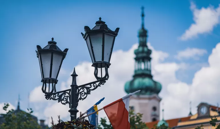 Latarnie na rynku z wieżą kościoła w tle